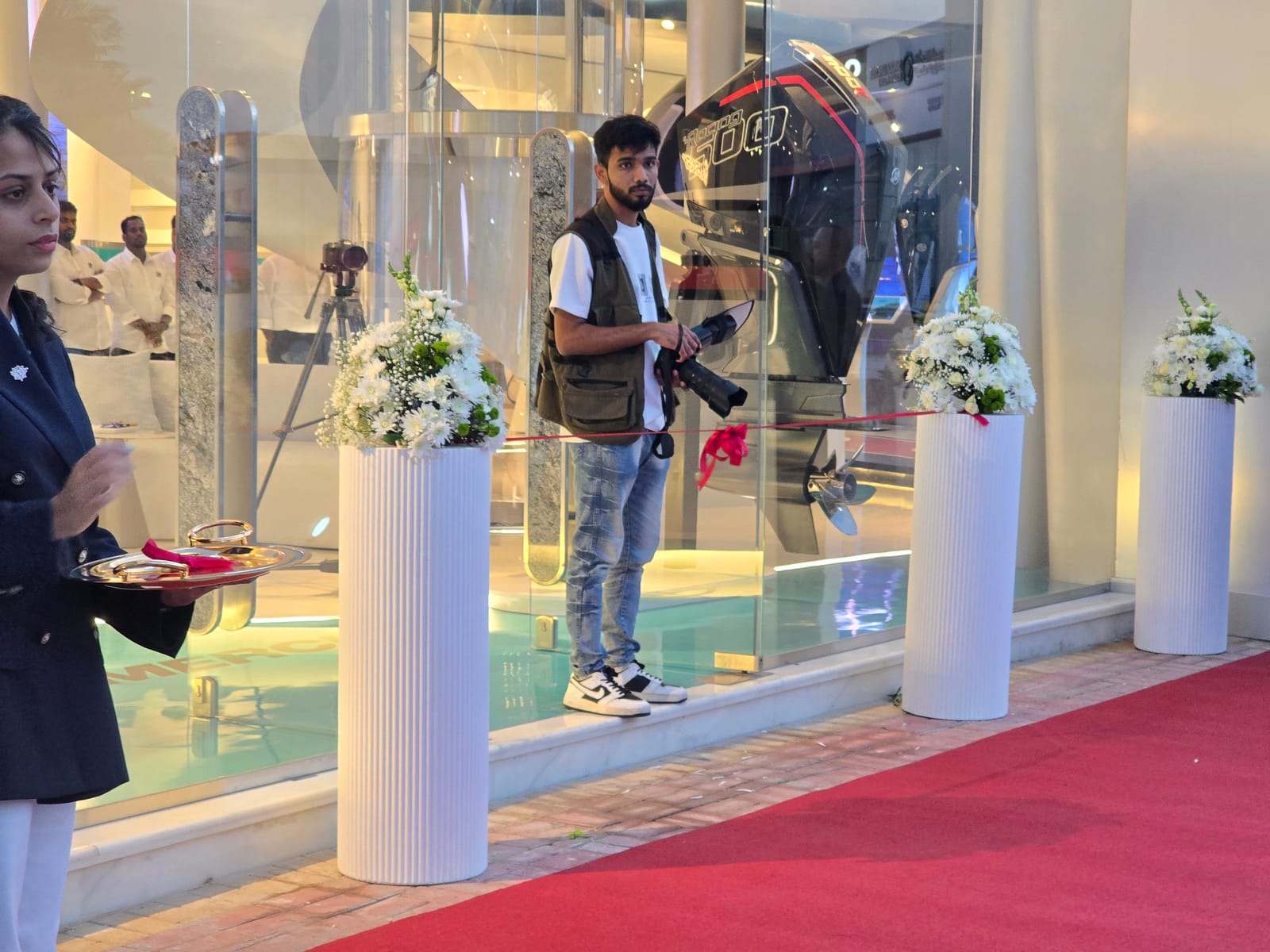Showroom entrance with floral arrangements and red carpet