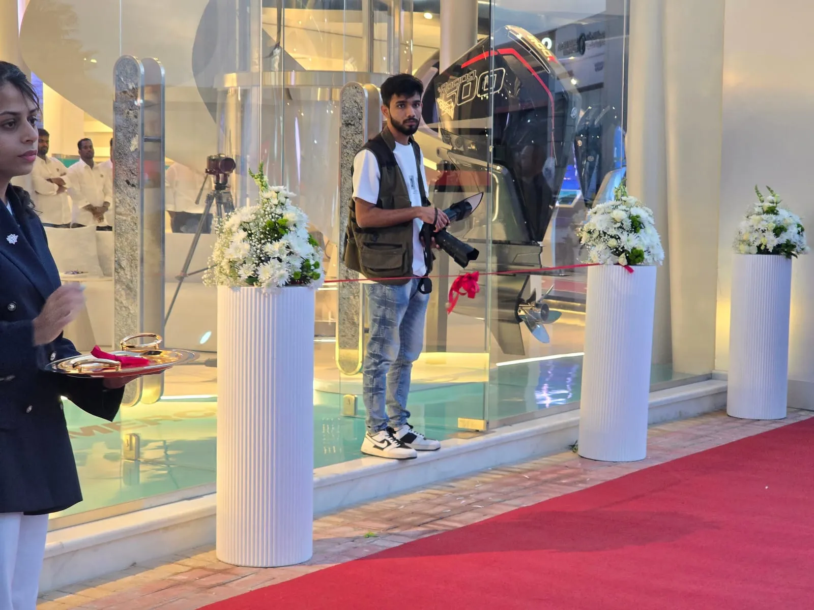 Showroom entrance with floral arrangements and red carpet