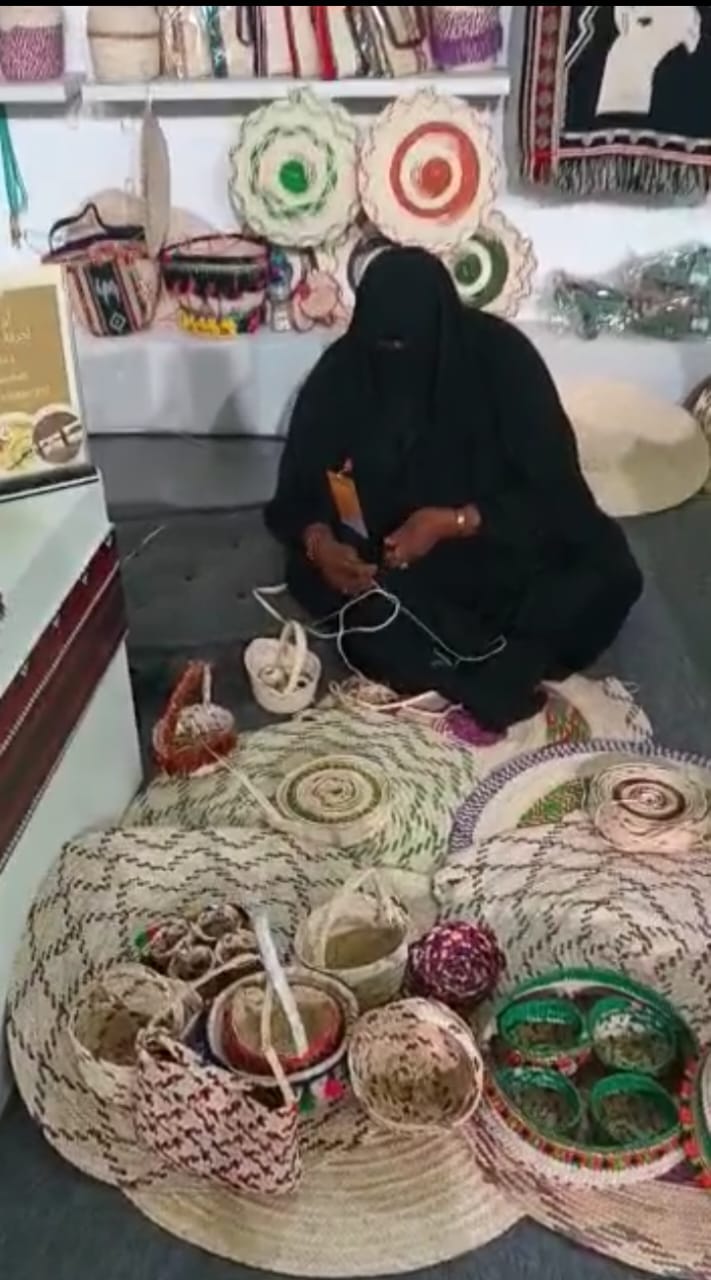 Sadu artisan with handwoven baskets display