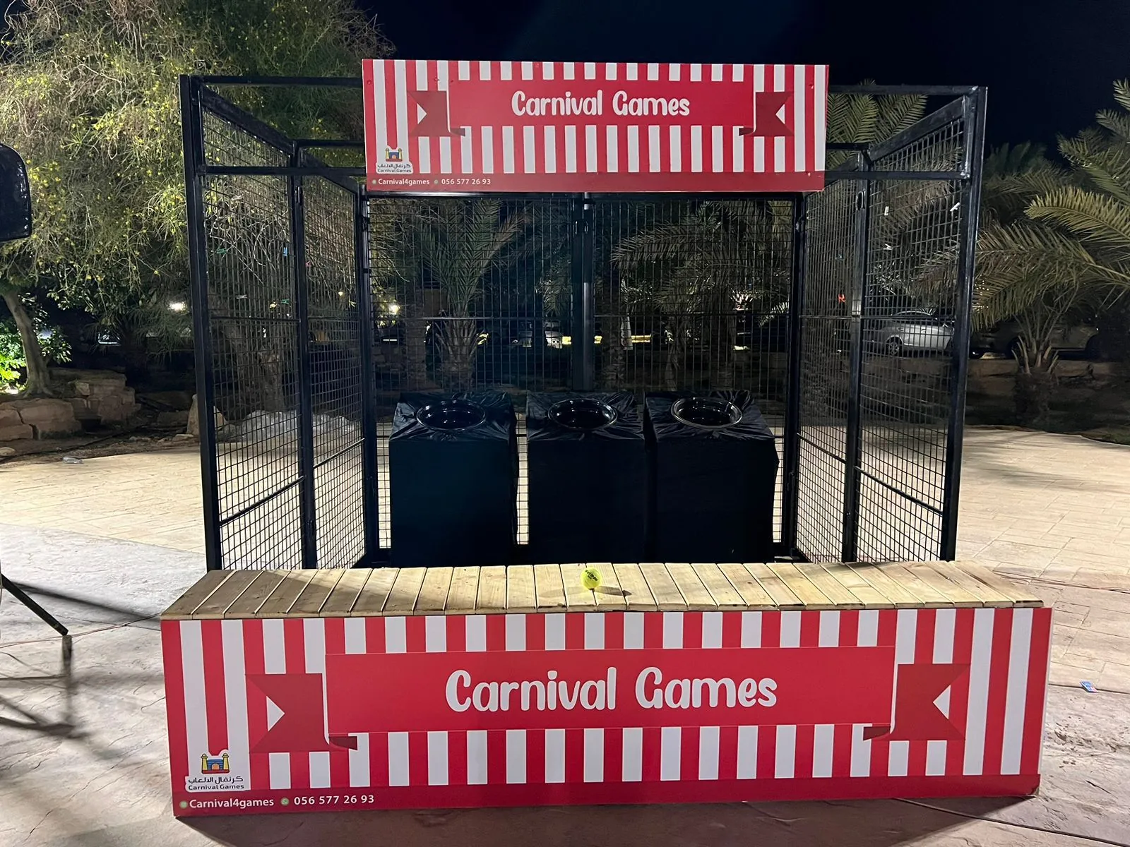Outdoor carnival games booth with a striped counter set up for a corporate open day
