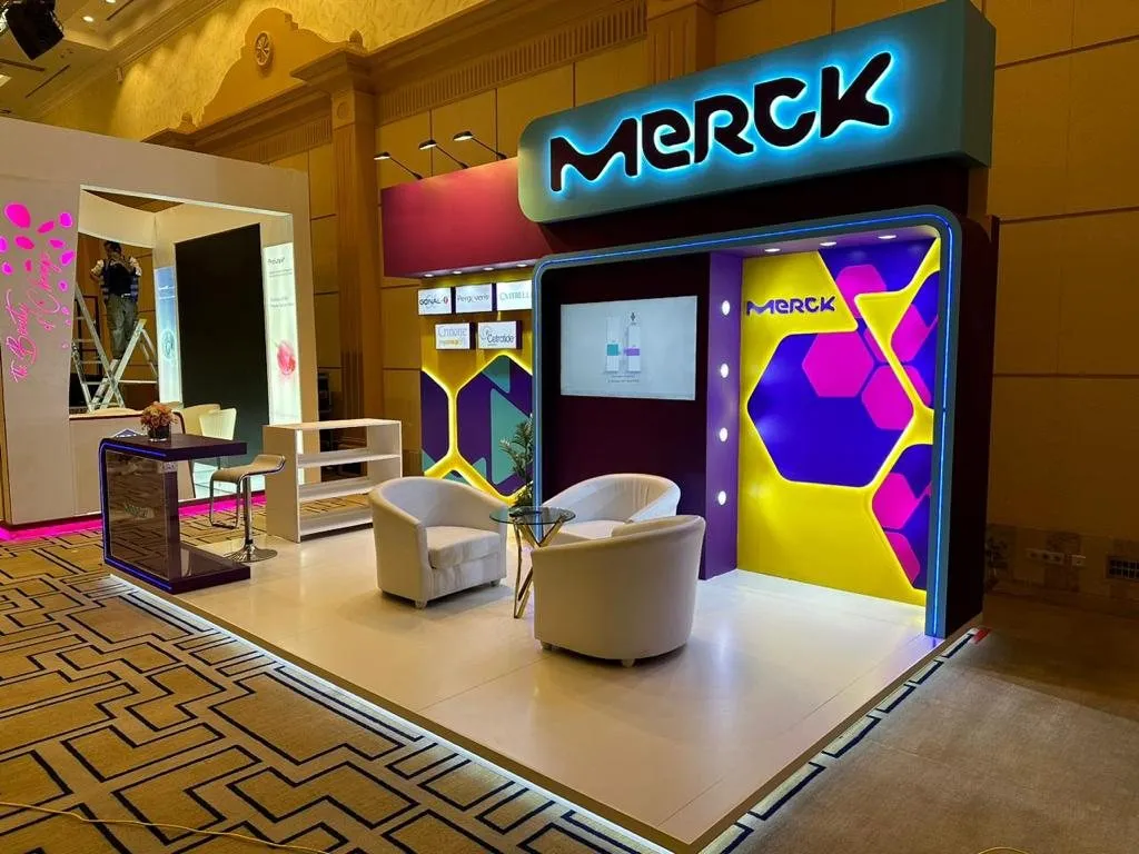 Merck booth with backlit hex wall and lounge