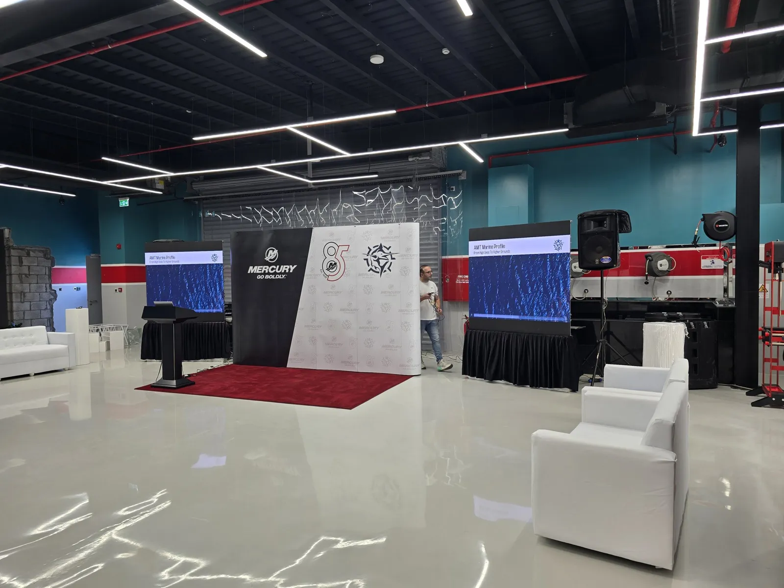 Showroom set: press wall, LED screens, lounge sofas